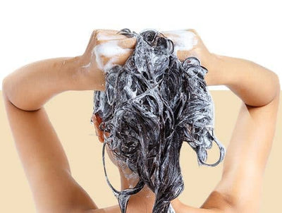 Woman washing her hair with keratin shampoo